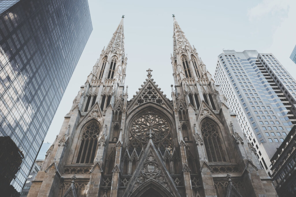 Twin Gothic cathedral spires rising above surrounding city skyscrapers