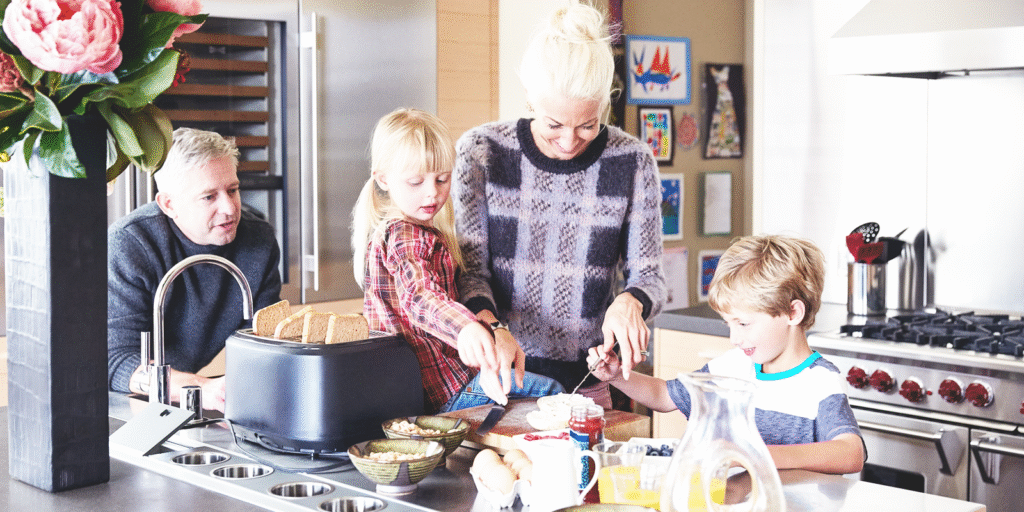 Family preparing breakfast together in the kitchen