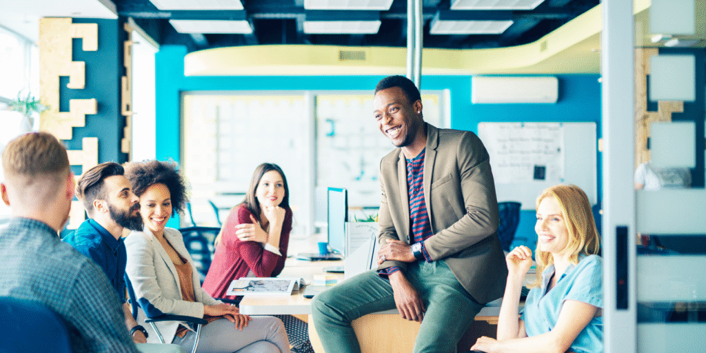 Coworkers laughing together in a colorful open office