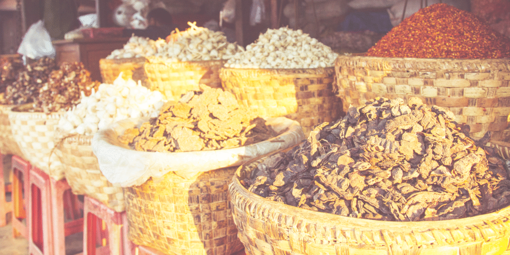 Baskets of dried spices and garlic at an outdoor market