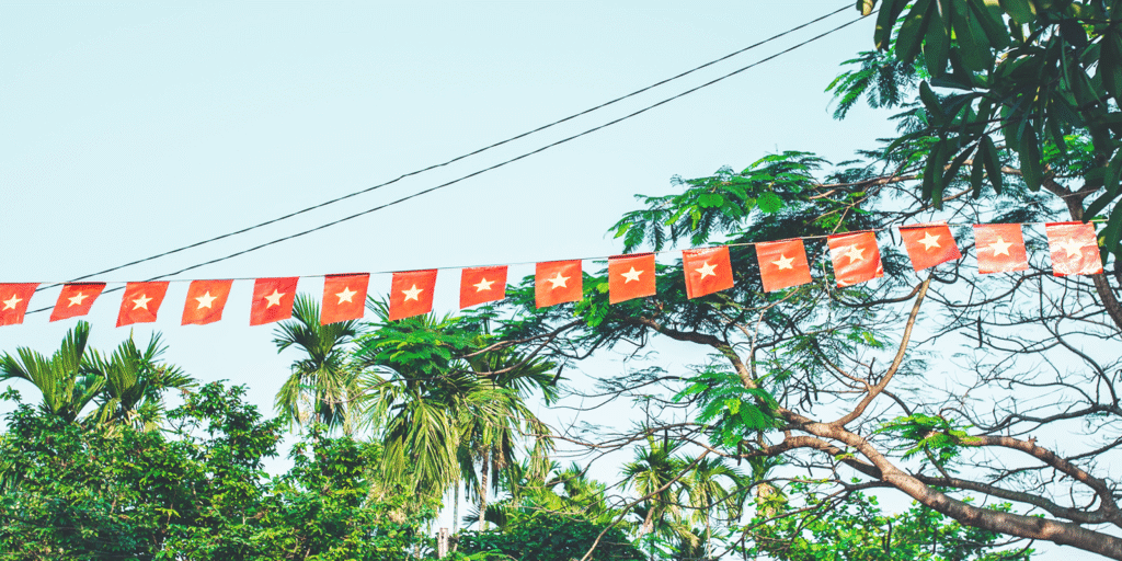 Red flags with white stars strung between trees